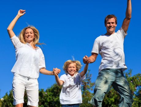 Lively family jumping in the air against thr blue sky
