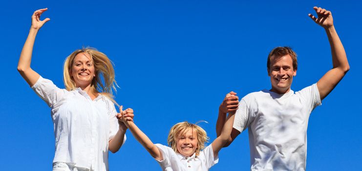 Cute family jumping in the air against thr blue sky
