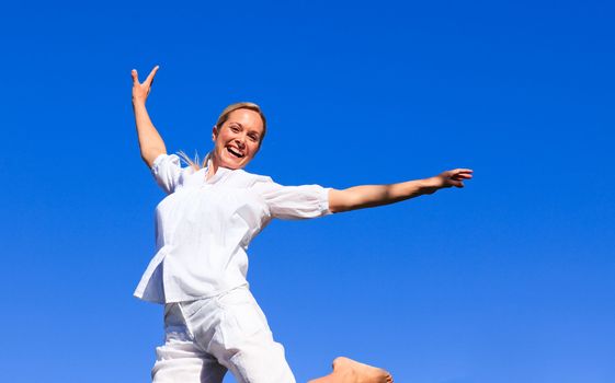 Happy woman having fun outdoors against blue sky