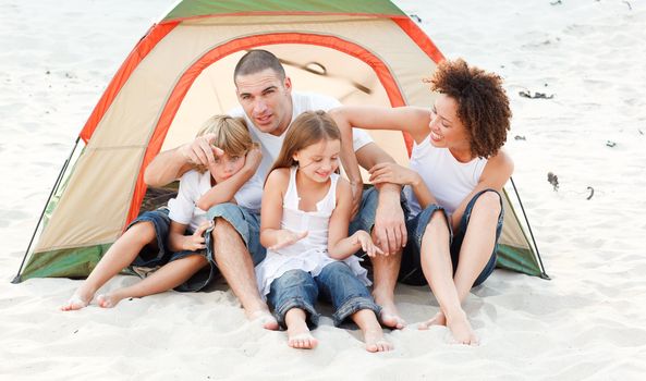 Happy young family camping on beach