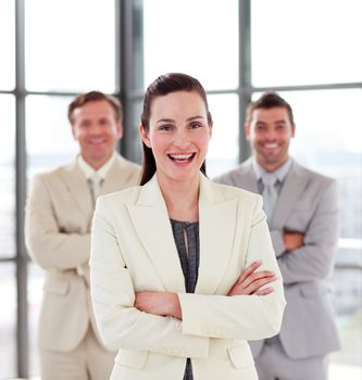 Smiling young businesswoman with her team in the background