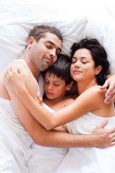 Young couple and son sleeping in bed 