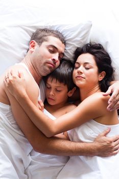 Happy young family sleeping in bed 