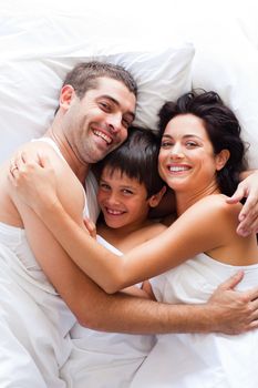Happy young family together in bed 