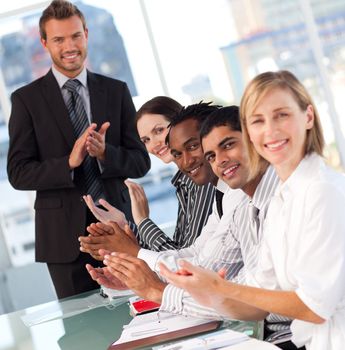 Business team clapping at the end of a presentation looking at the camera