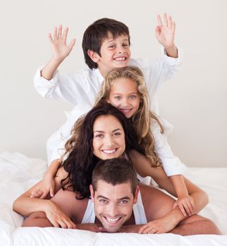 Delighted family lying on their bed