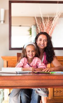 Radiant mother helping her daughter for homework