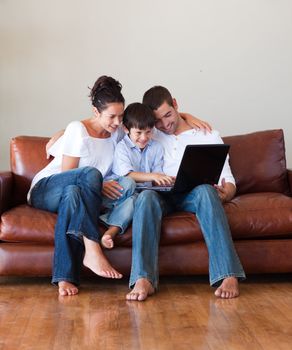 Parents and son playing with a laptop at home