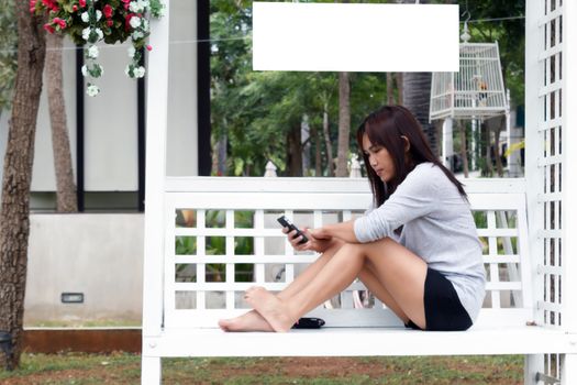 Woman sit on chair using mobile phone.