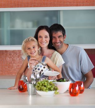 Smiling family eating in a kitchen
