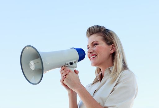 Businesswoman shouting through megaphone outdoors
