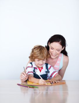 Mother helping her son to draw at home