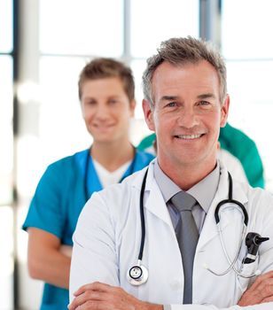 Portrait of a mature doctor leading his team in hospital