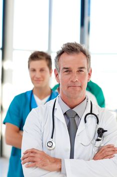 Frinedly mature doctor leading his team in hospital