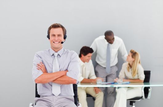 Young and handsome businessman with a headset on in an office