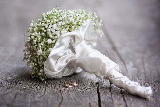 Wedding  bouquet and rings on a dark wooden background.