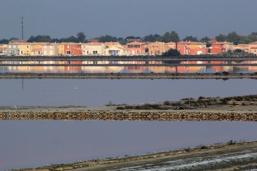 Colorful houses reflecting in water at Salin de Giraud, Camargue, France
