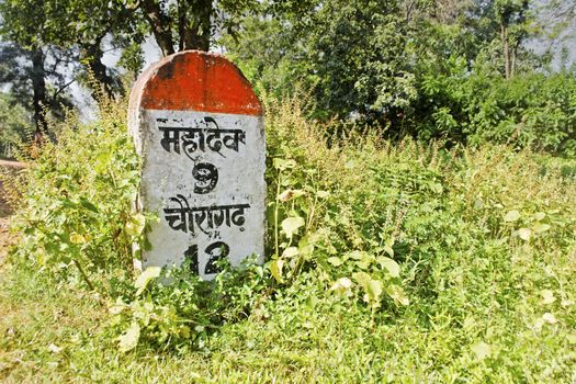 Milestone indicating 9 kilometers to Mahadev. Shot location Pachmarchi, Madhya Pradesh, India