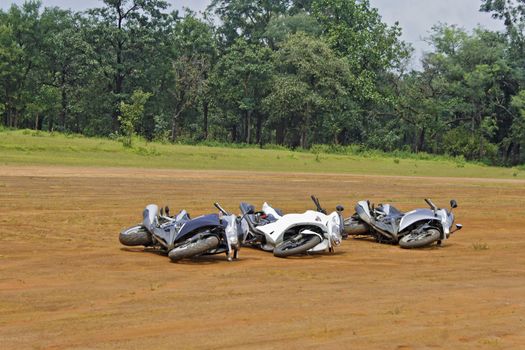 Three generic motorbikes dropped on their side. Concept, play dead they might go away. Location of shot India