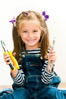 little smiling girl with old pliers and wrench