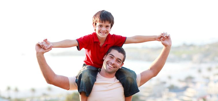 Young man giving child piggyback ride outdoors