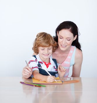 Cute mother and son doing homework together against a white background