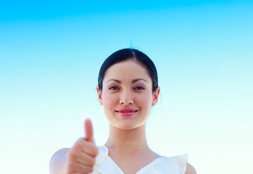 Portrait of a young businesswoman outdoors with thumbs up