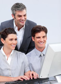 Joyful business team working at a computer in the office