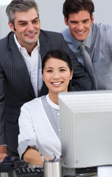 Positive business people working together at a computer in the office
