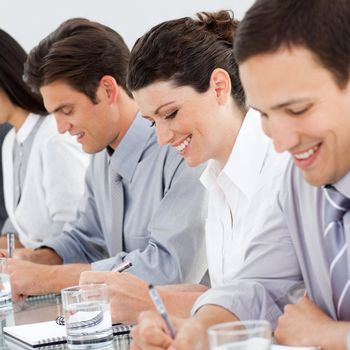 Young business people taking notes at a conference in the office