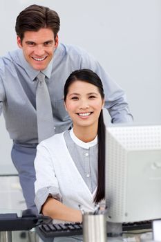 Jolly businesswoman helping by her manager in the office