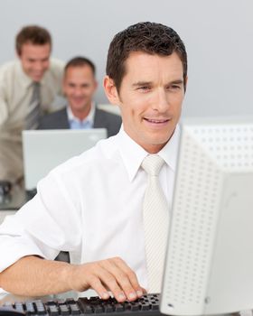 Smiling businessman working with a computer in the office