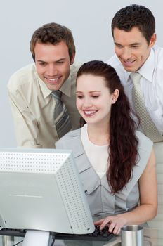 Businessmen helping a businesswoman with a computer in the office