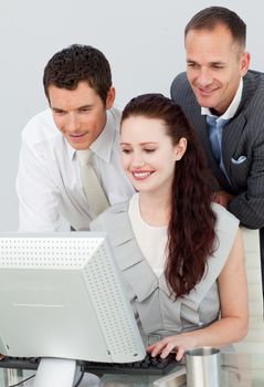 Three business people using a computer in the office