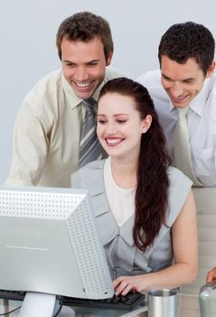 Businessmen helping her colleague with a computer in an office