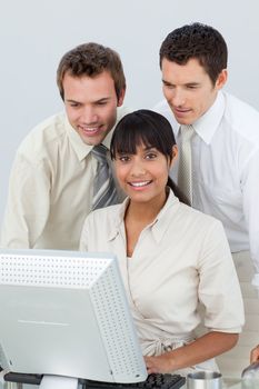 Businessmen and Afro-American businesswoman in the office using a laptop