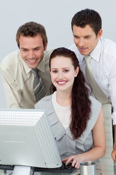 Three young business people using a computer in the office