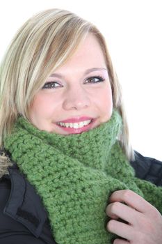 Beautiful cheerful woman wrapped in a warm green knitted wool winter scarf isolated on white