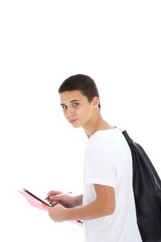 Teenage student boy with a large kit bag slung over his shoulder writing notes on a handheld folder, standing sideways looking at the camera isolated on white