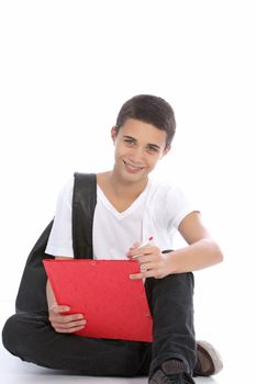 Cheerful teenage boy sitting curled up on the floor with a clipboard writing notes for his studies at college