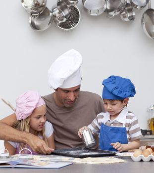 Father baking cookies with his children in the kitchen