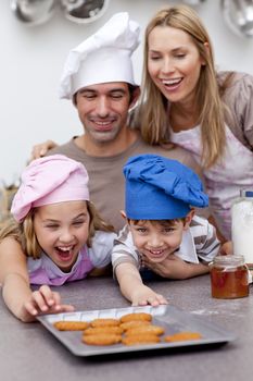 Children and parents eating cookies after baking in the kitchen