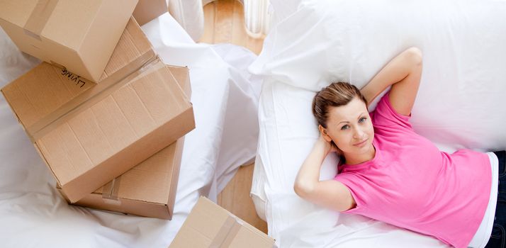 Cheerful woman relaxing between boxes at home