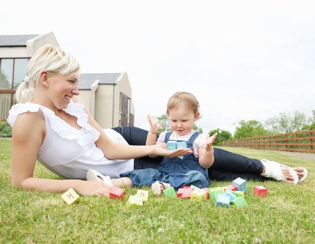 Smiling mother and daughter having fun in the garden 