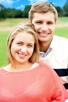 Closeup shot of an attractive love couple. Man hugging his wife from behind