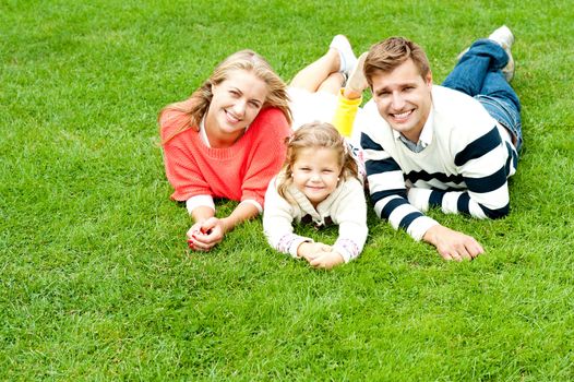 Laughing family of three having fun together on a sunny summer day