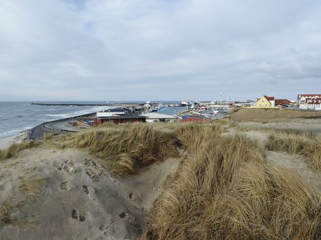 coastline in north Denmark with houses, grass and cloudy sky