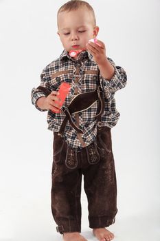 Bavarian boy in leather pants playing with soap bubbles