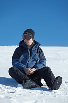 Skier resting sitting in the snow