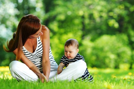 Happy mother and daughter on the green grass